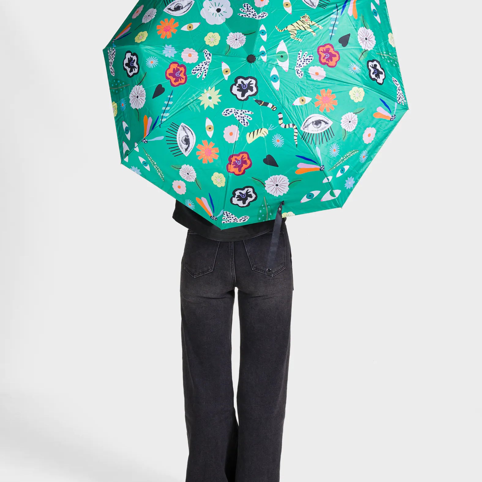 Person holding a green floral-patterned umbrella on a white background