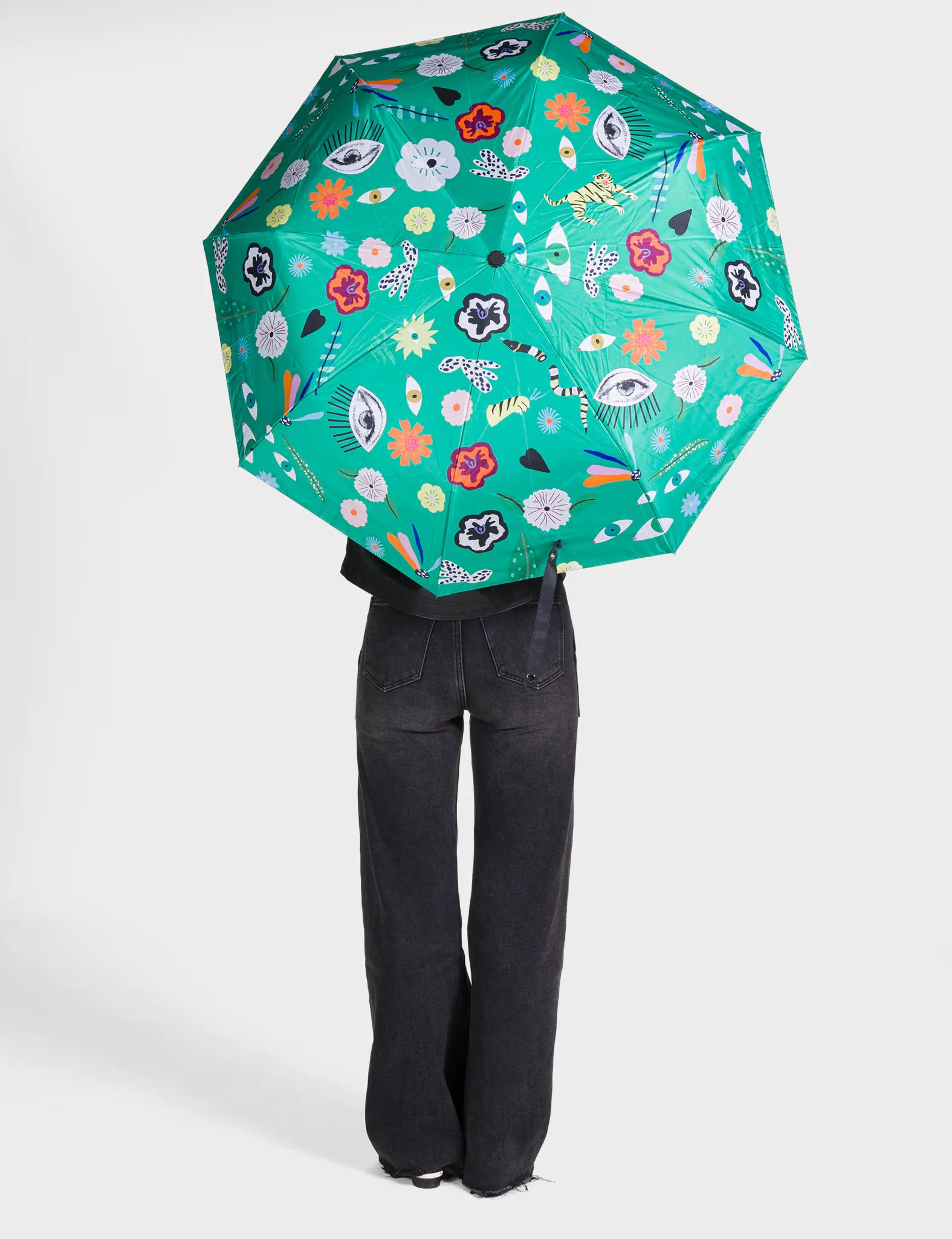 Person holding a green floral-patterned umbrella on a white background