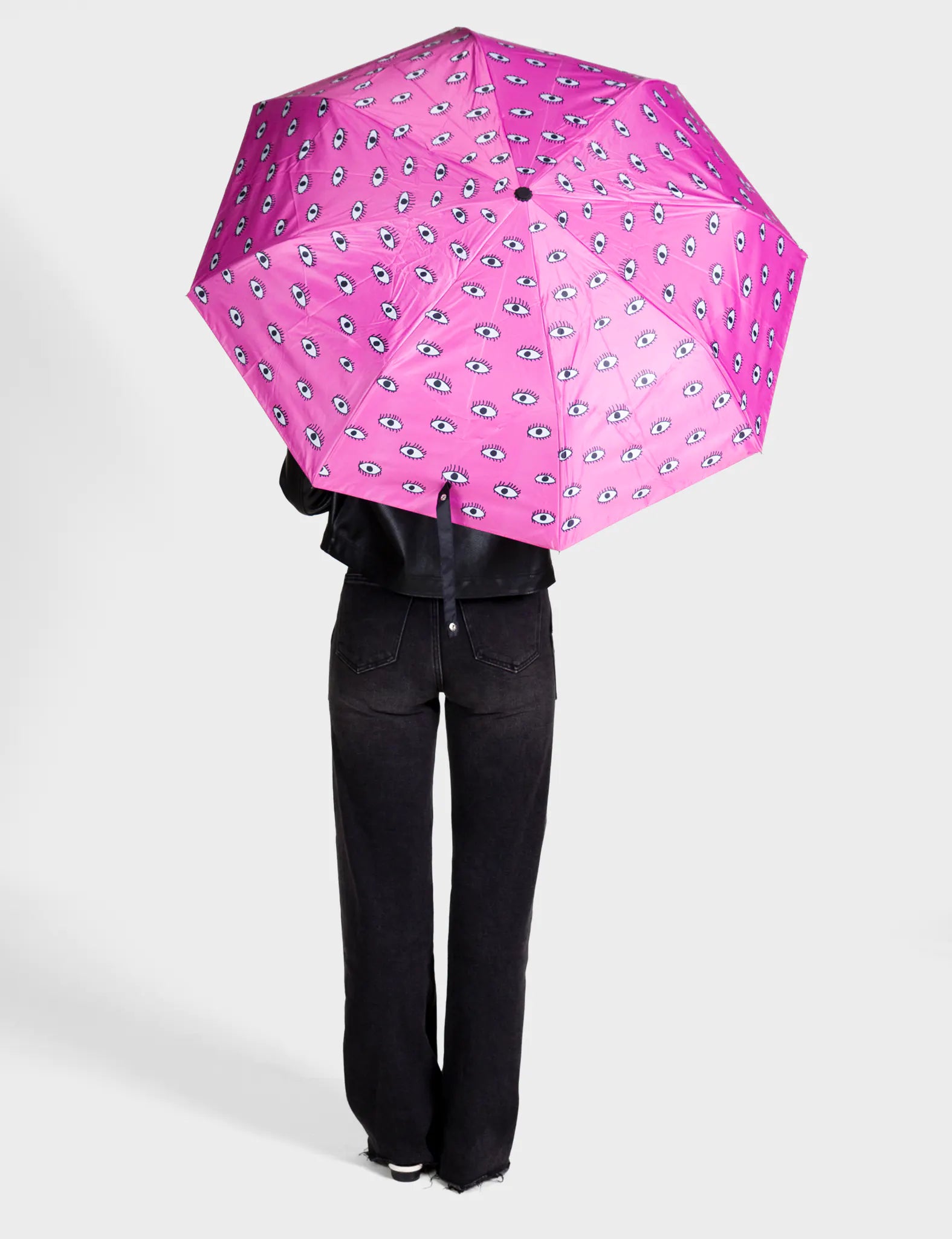 Person holding a pink umbrella with a pattern on a white background