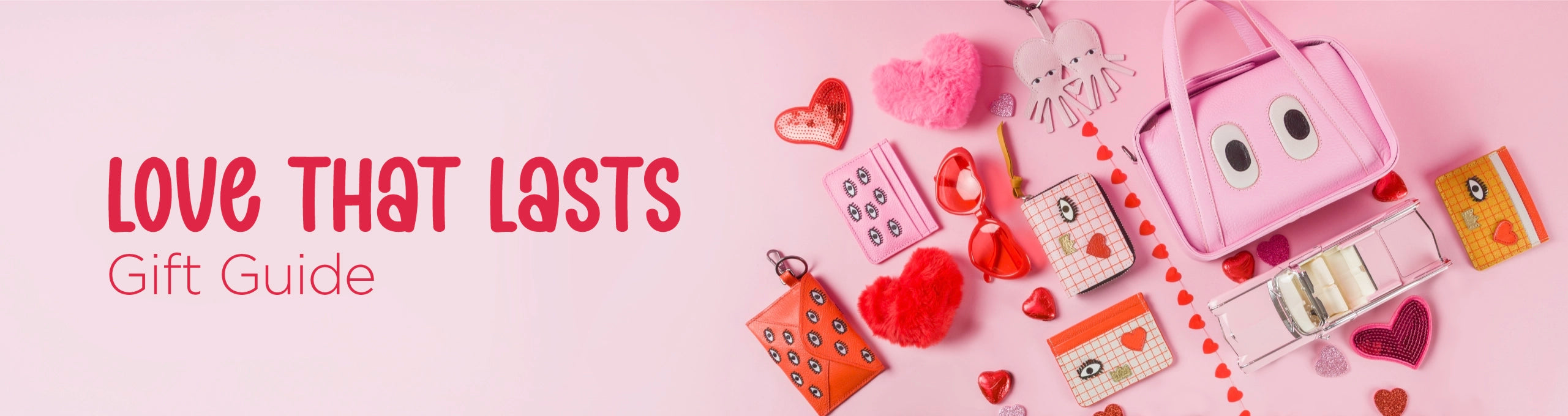 Wide pink banner featuring a flat lay of Min & Mon bags, wallets, and accessories styled with heart details, introducing the “Love That Lasts” Valentine gift guide.