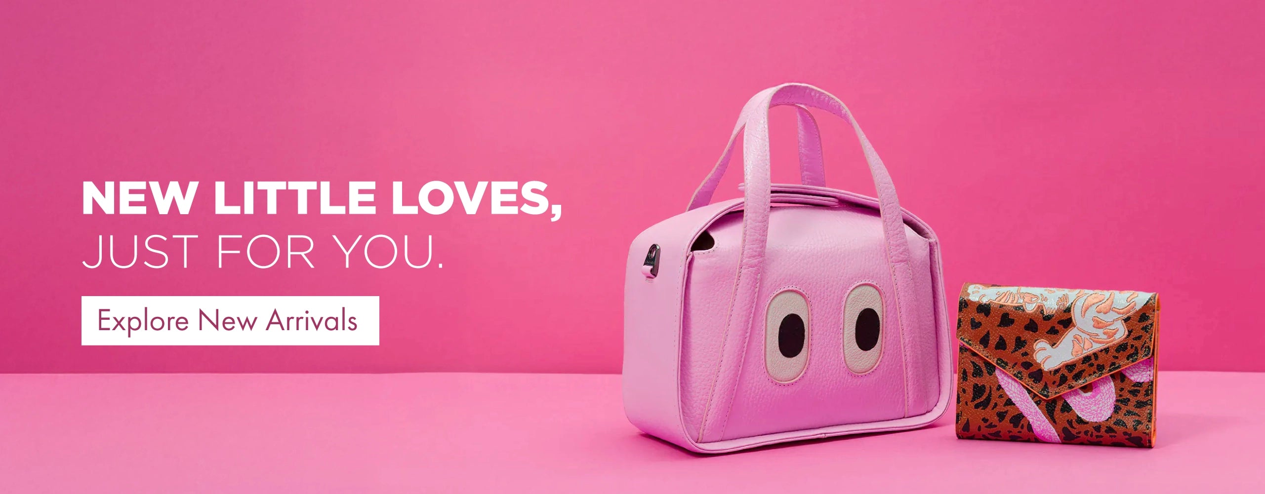 Pink Min & Mon mini handbag with signature eye detail next to a patterned leather wallet on a pink background.