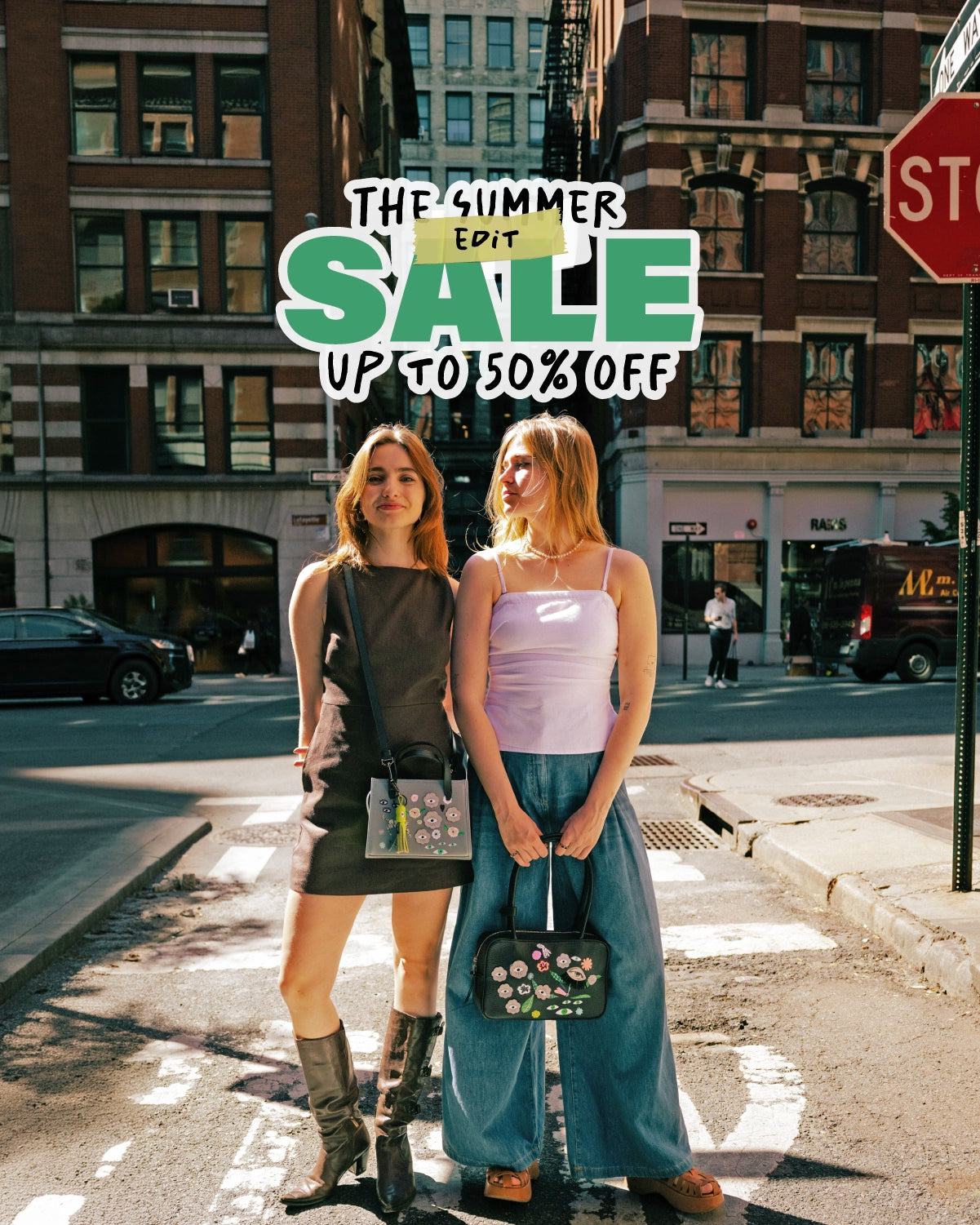 Full-length shot of two people on a city street with buildings in the background, holding Min & Mon embroidered purses. At the top, stylized text reads "The Summer Edit SALE up to 50% OFF" in green and white.