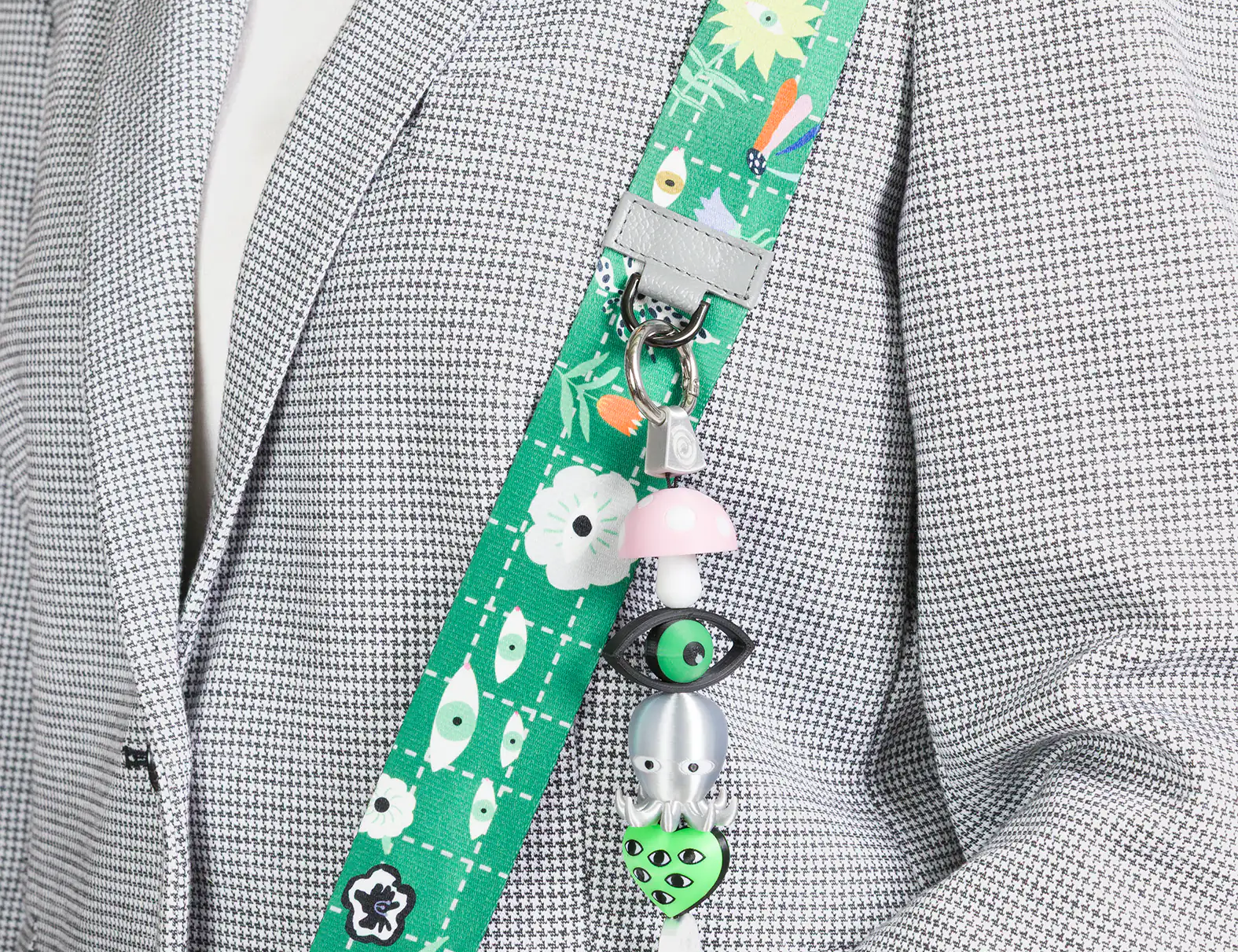 Green lanyard with cartoon characters attached to a gray blazer.