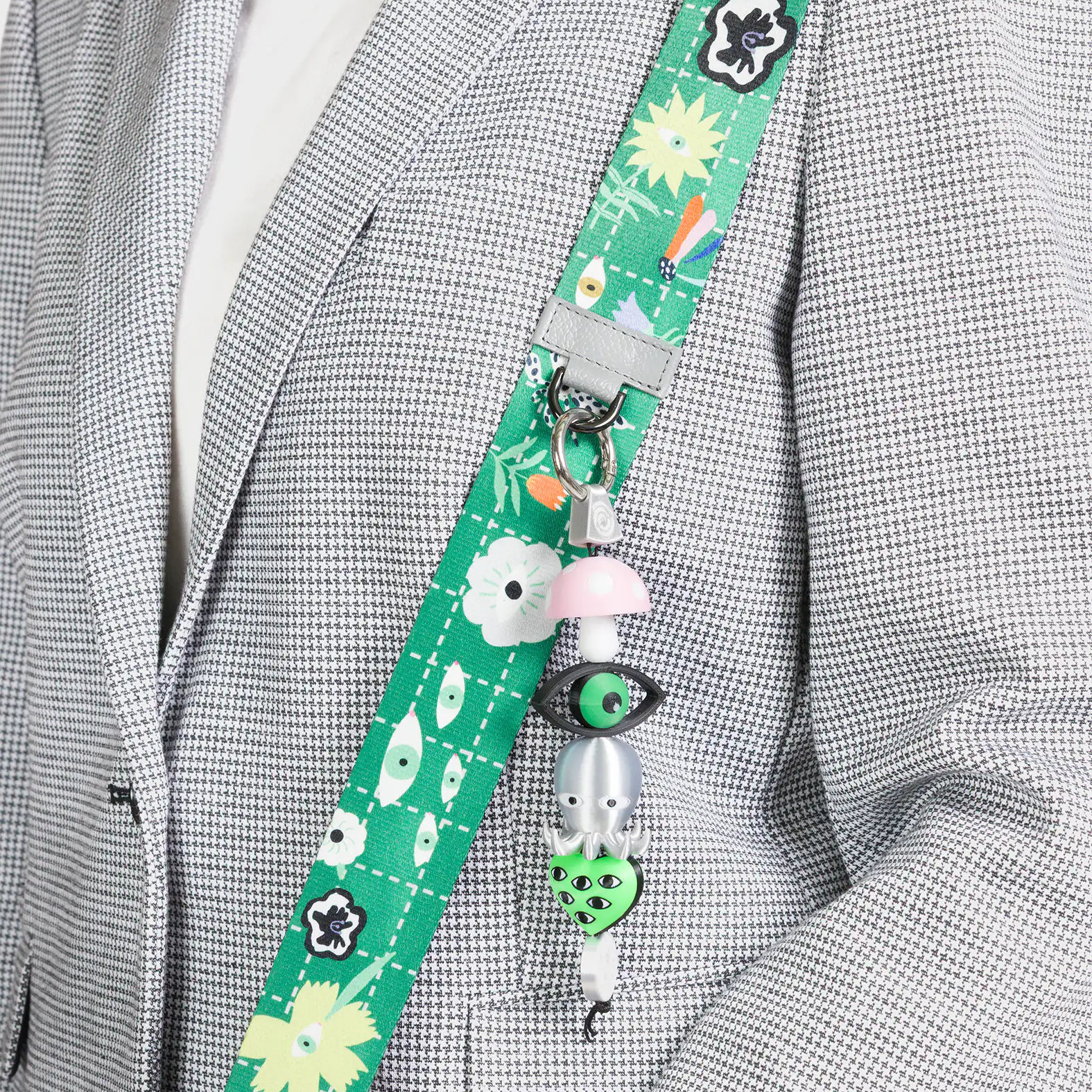 Green lanyard with cartoon characters attached to a gray blazer.
