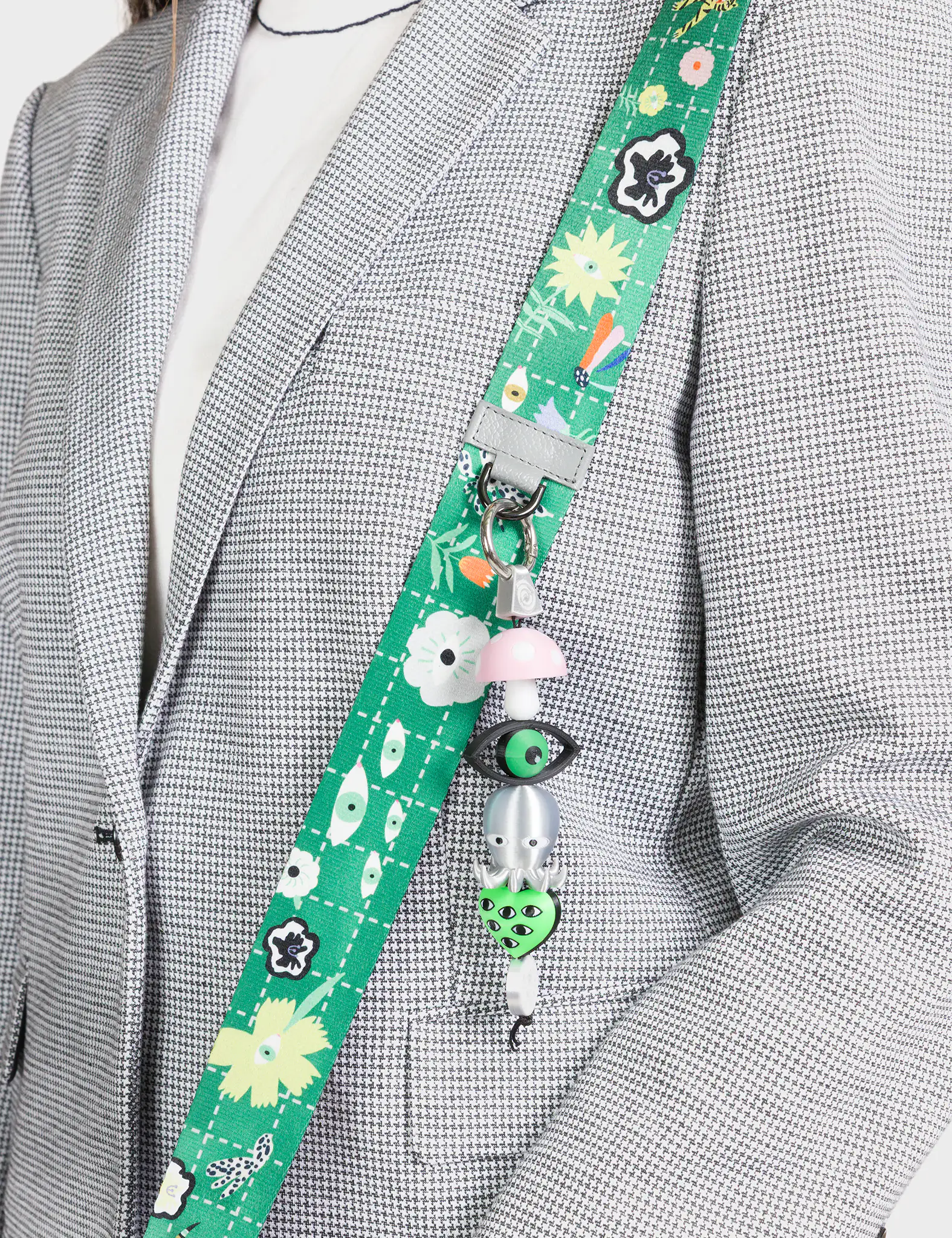 Green lanyard with cartoon characters attached to a gray blazer.
