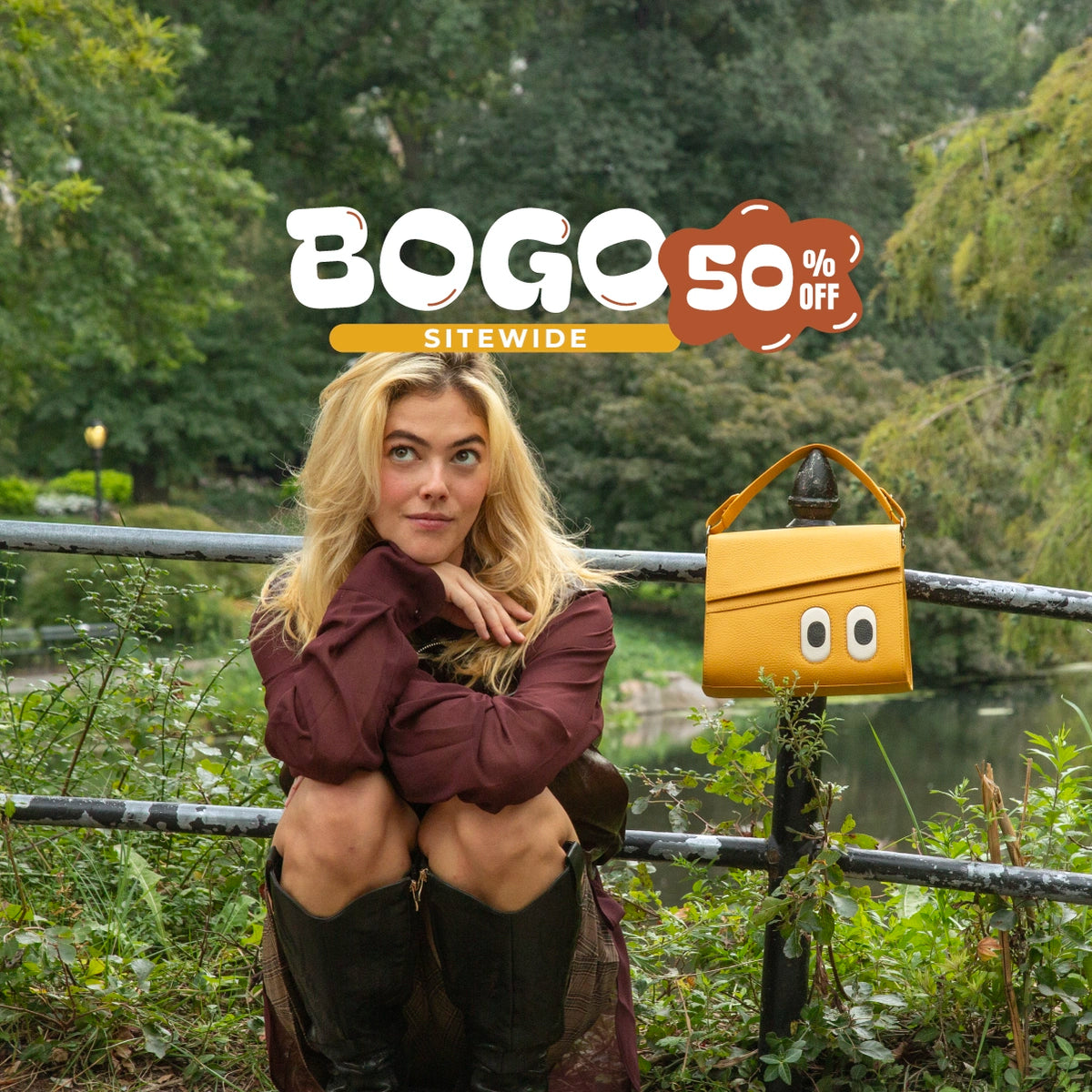 Close-up of a blonde model wearing a burgundy jacket and black boots, sitting beside a mustard yellow Min & Mon Anastasio handbag with playful embroidered eyes, from the Look Up collection.
Featuring a ‘BOGO 50% OFF Sitewide’ promotional graphic.