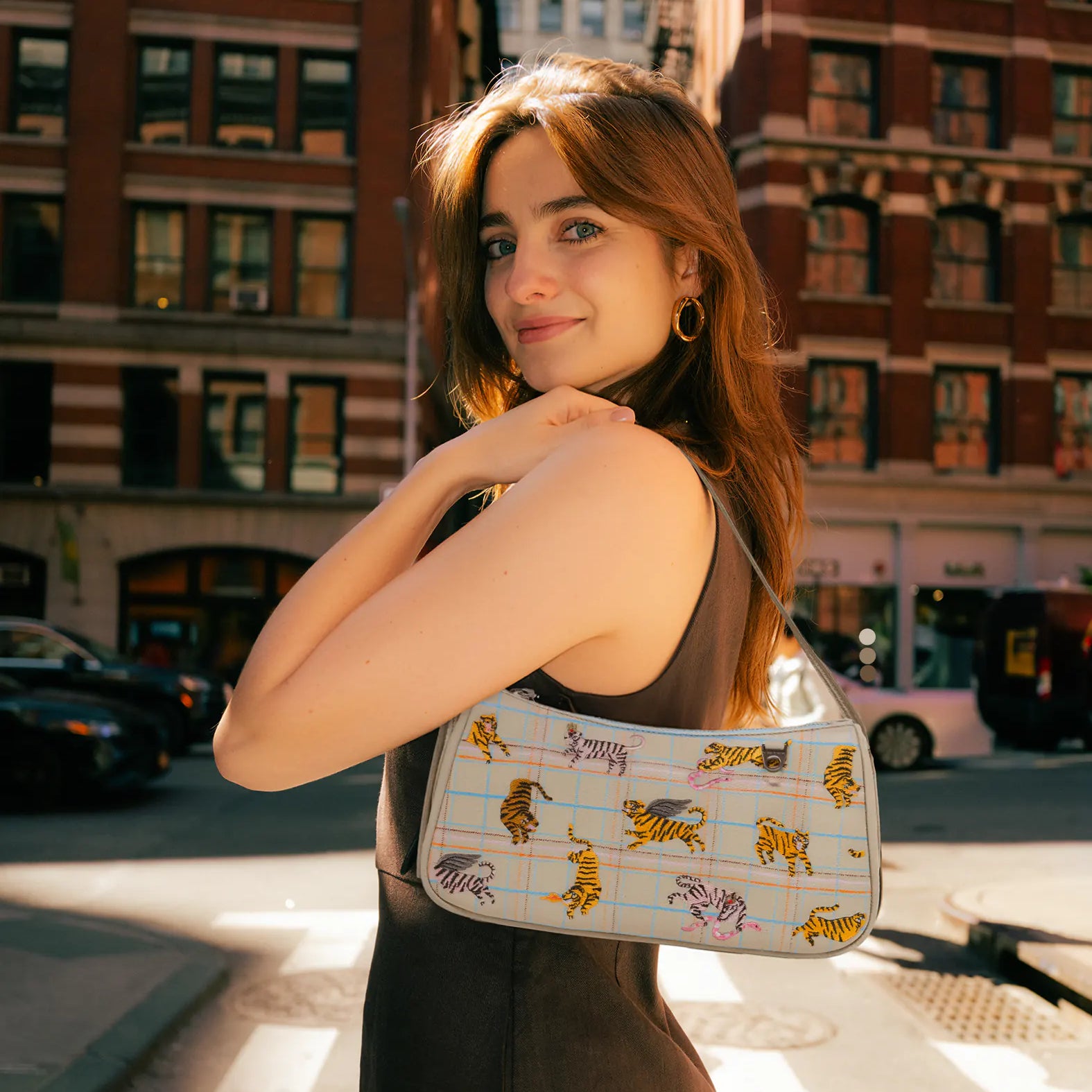 Woman holding a patterned handbag on a city street