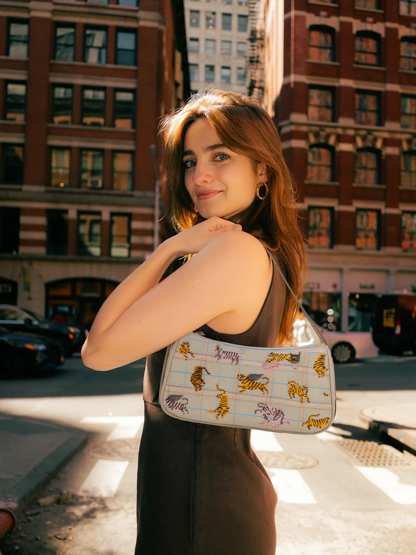 Woman holding a patterned handbag on a city street