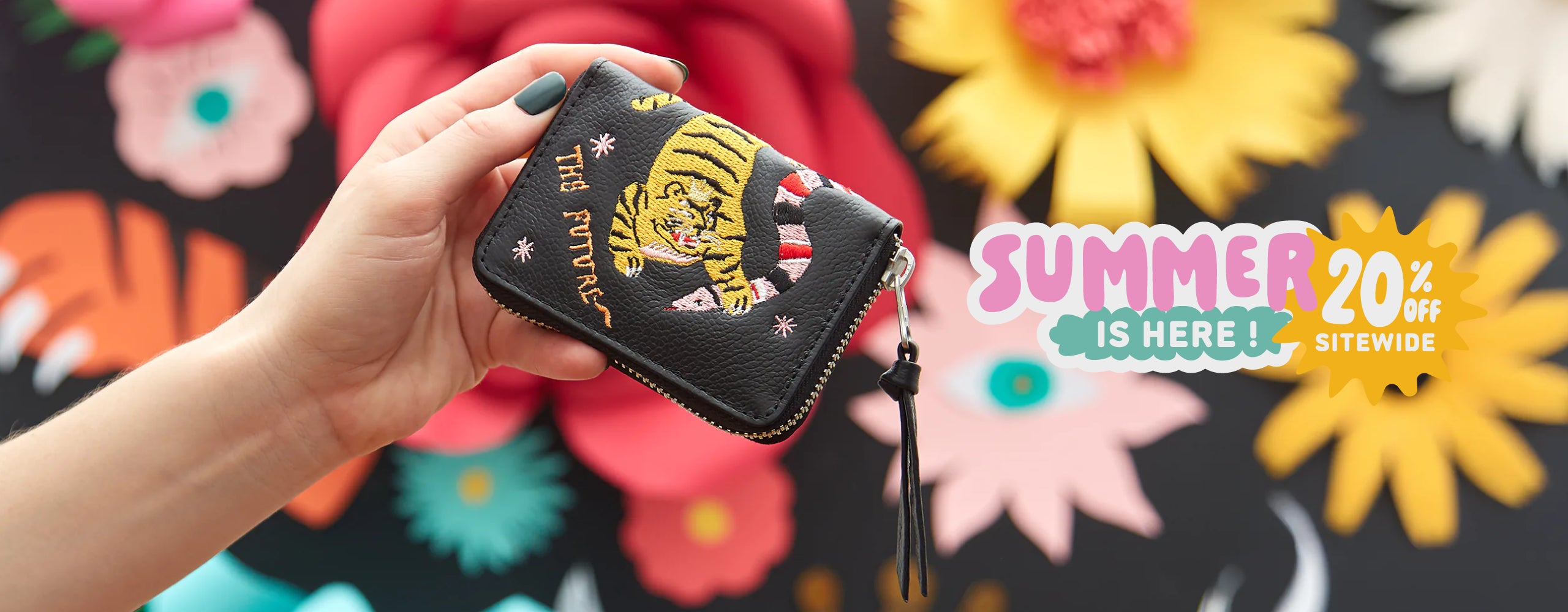 Min & Mon wallet with embroidered tiger displayed against a colorful floral backdrop in the Summer is Here campaign featuring 20% OFF sitewide.
