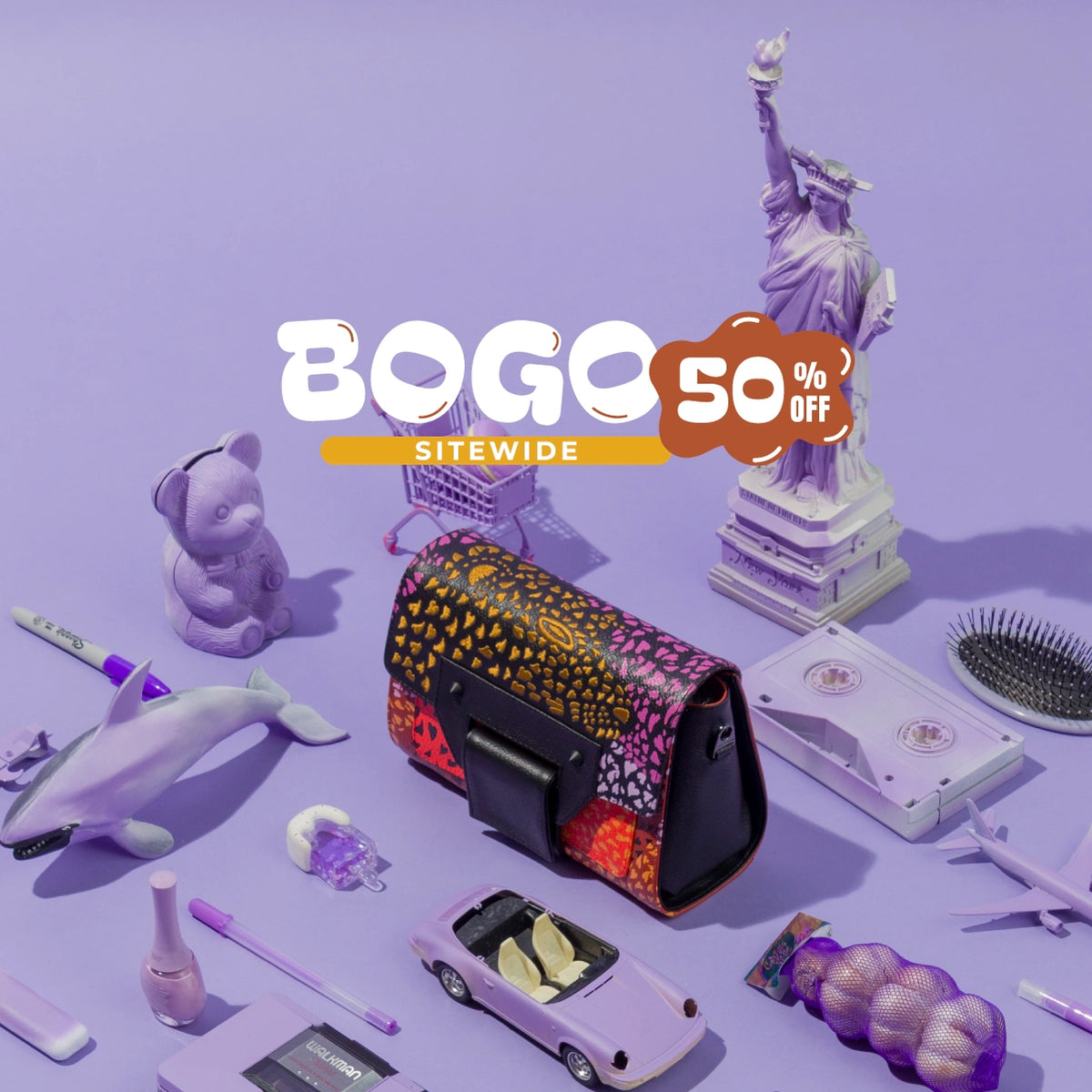 Close-up of the Min & Mon Cael bag with a vibrant multicolor print and black leather details, styled with purple toys and miniature New York City landmarks.
Featuring a ‘BOGO 50% OFF Sitewide’ promotional graphic.