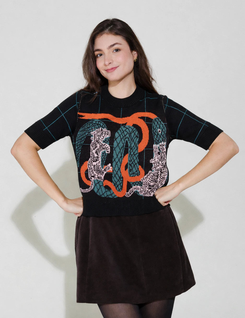 Woman wearing a black sweater with a colorful design on a white background