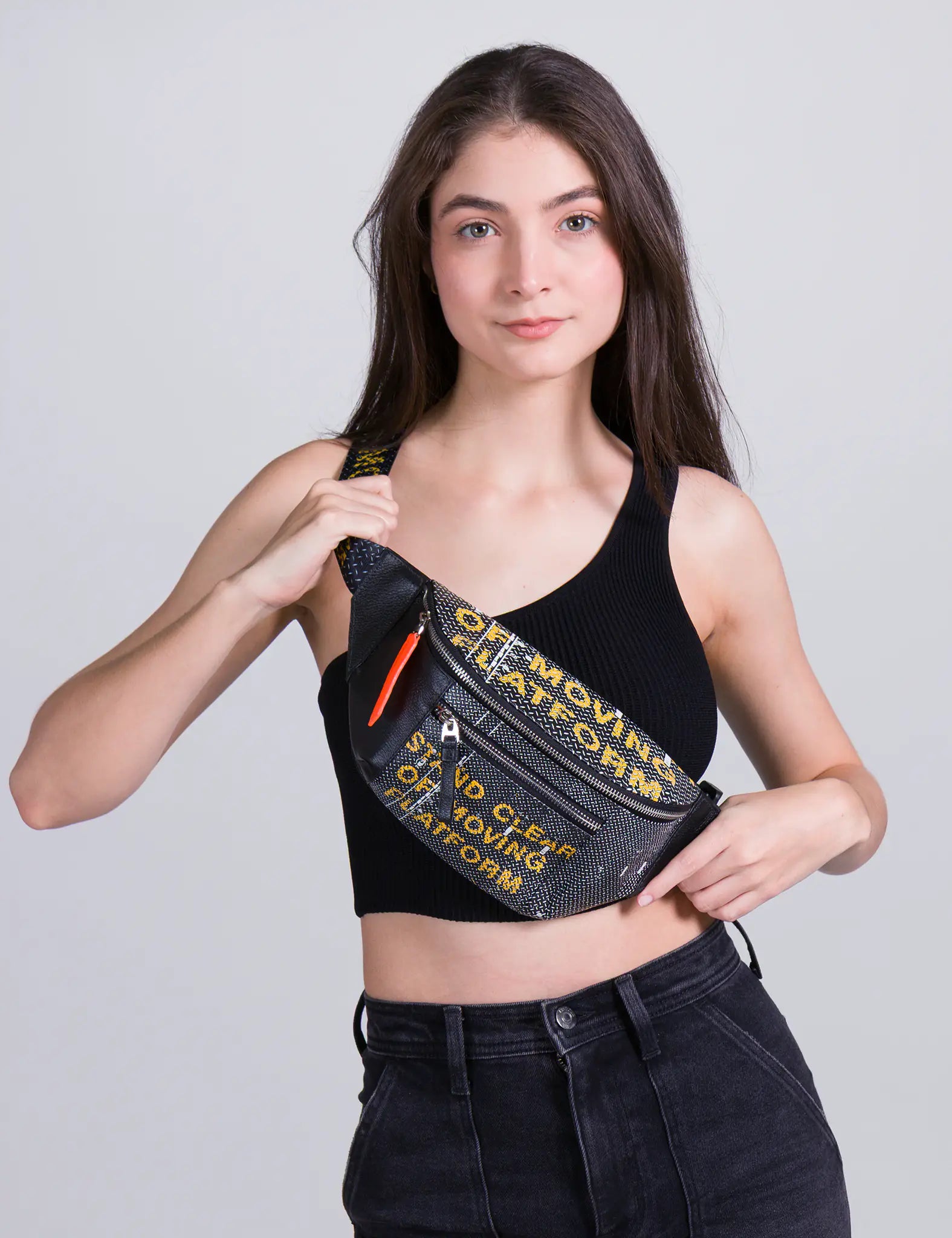 ChatGPT dijo:
Woman wearing a black crop top and high-waisted jeans, modeling a crossbody Min & Mon Fanny Pack with yellow text against a neutral background.